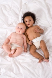 Multiracial babies lying together side by side